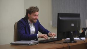 Active businessman rejoices success. In the office, sitting at the computer